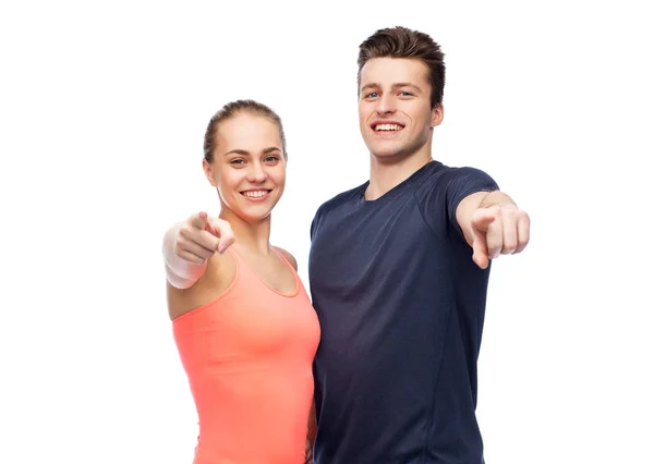 Happy sportive man and woman pointing finger — Stock Photo, Image
