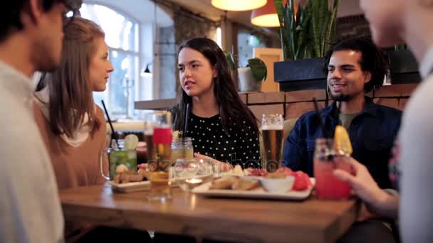 Amigos felizes comendo e bebendo no bar ou café — Vídeo de Stock
