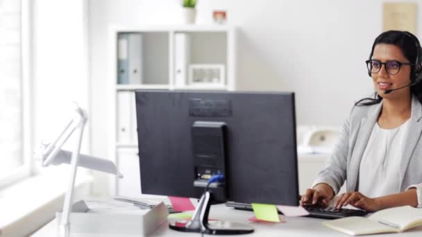 Geschäftsfrau mit Headset und Computer im Büro — Stockvideo