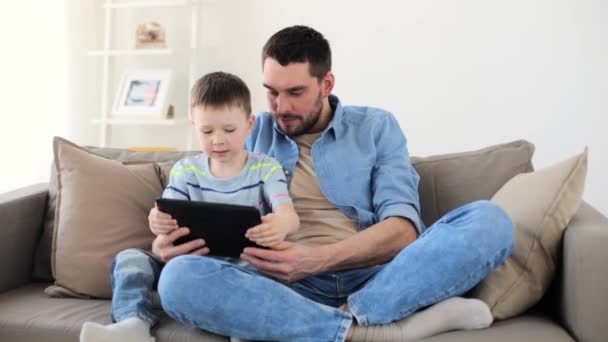 Отец и сын с планшетным компьютером играют дома — стоковое видео