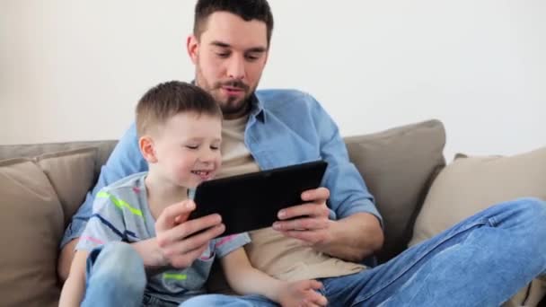 Far och son med tablet pc spelar hemma — Stockvideo