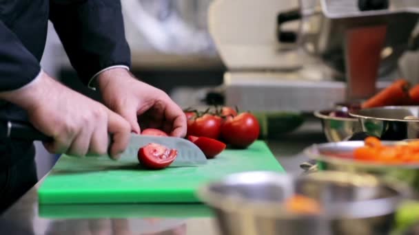 Hände eines männlichen Kochs, der Tomaten in der Küche hackt — Stockvideo