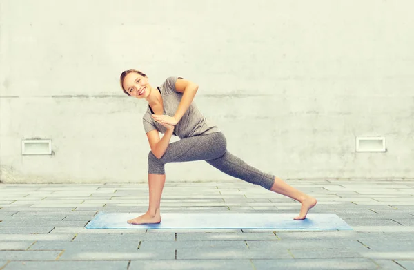 Žena dělat jógu nízký úhel výpadem pozice na mat — Stock fotografie