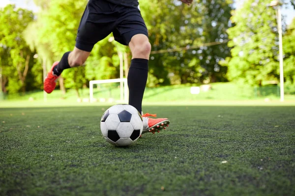 Jugador de fútbol jugando con pelota en el campo — Foto de Stock