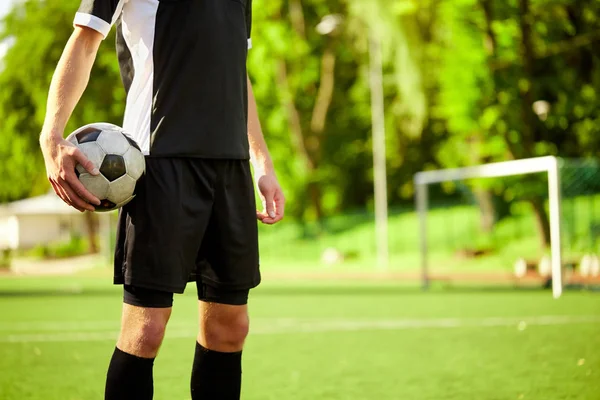 Футболист с мячом на футбольном поле — стоковое фото