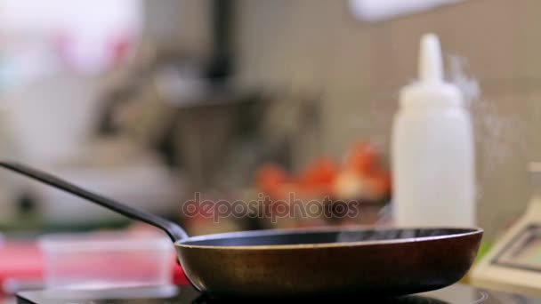 Сковородка на плите на кухне — стоковое видео