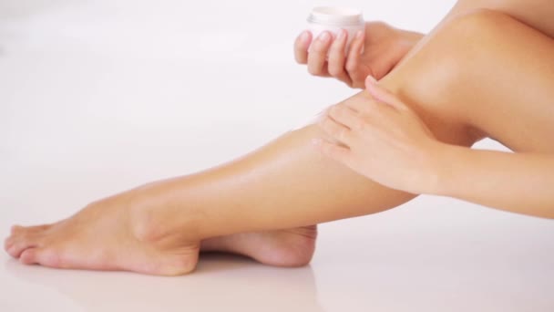 Mulher aplicando creme hidratante na perna — Vídeo de Stock