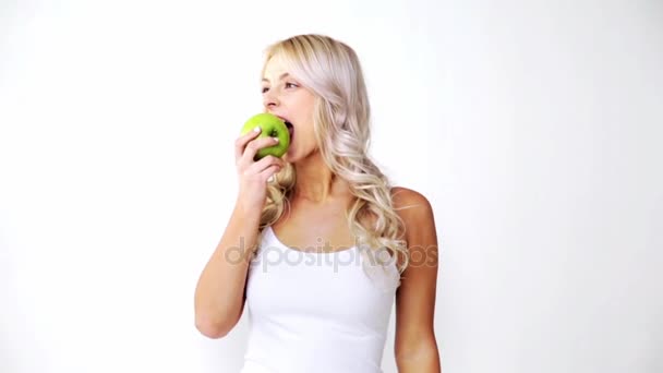 Happy beautiful young woman eating green apple — Stock Video