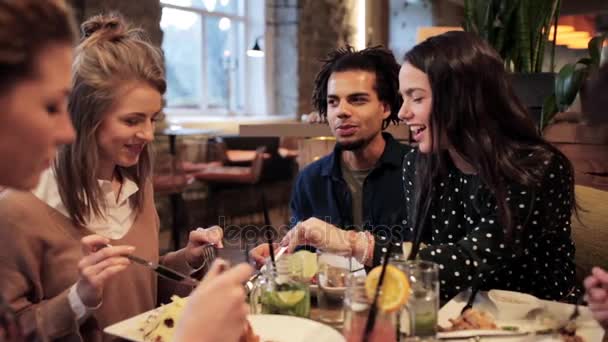 Happy vrienden eten en drinken in restaurant — Stockvideo