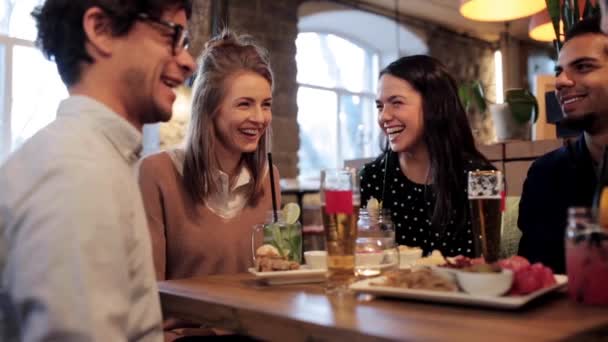 Happy friends eating and drinking at restaurant — Stock Video