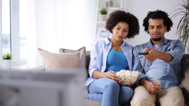 Gülümseyen çift evde tv izlerken patlamış mısır ile — Stok video