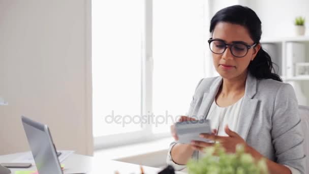 Деловая женщина с калькулятором подсчета в офисе — стоковое видео