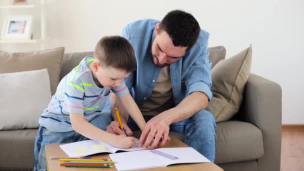 Pai e filho pequeno com lápis de cor desenho em casa — Vídeo de Stock