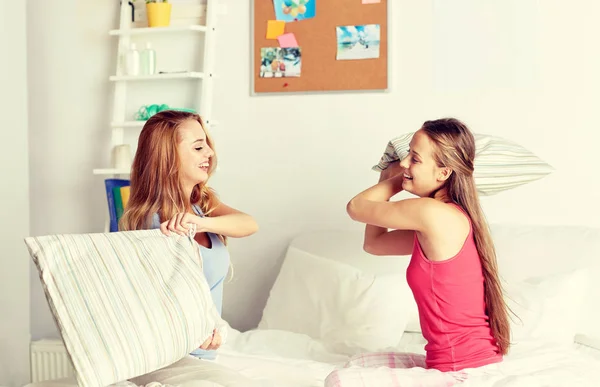 Feliz adolescente menina amigos lutando travesseiros em casa — Fotografia de Stock