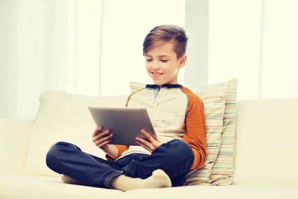 Lachende jongen met tablet pc thuis — Stockfoto