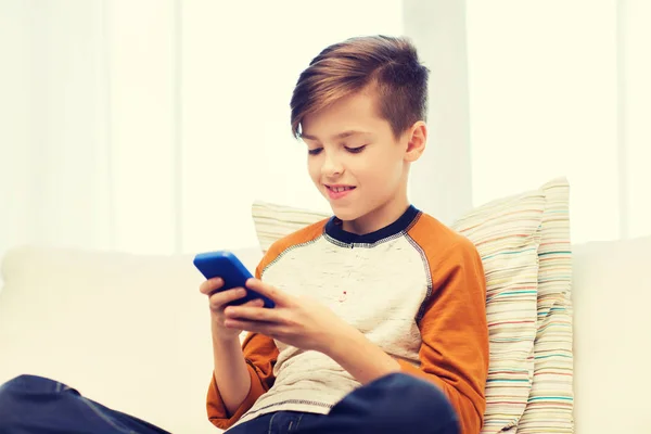 Boy with smartphone texting or playing at home — Stock Photo, Image