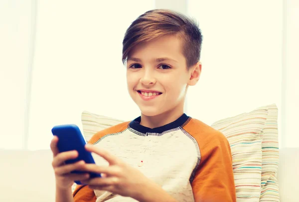 Niño con mensajes de texto de teléfonos inteligentes o jugando en casa — Foto de Stock