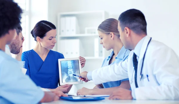 Grupp läkare med röntgen på TabletPC på klinik — Stockfoto