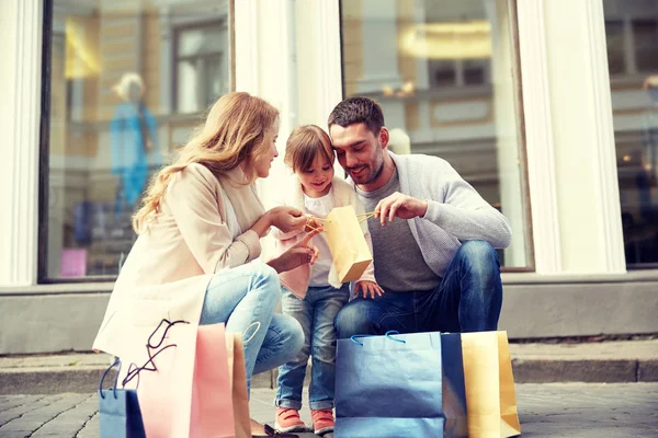 Famiglia felice con bambino e shopping bag in città — Foto Stock