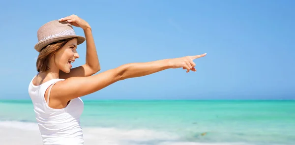 Glückliche junge Frau mit Hut am Sommerstrand — Stockfoto