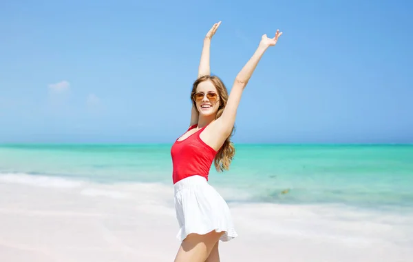 Happy young woman in sunglasses on summer beach — Stock Photo, Image