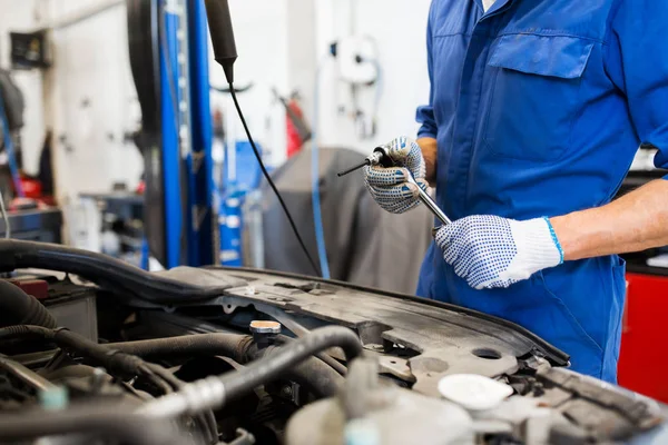 Mechaniker mit Schraubenschlüssel repariert Auto in Werkstatt — Stockfoto