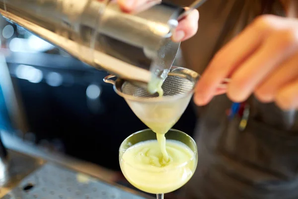 Barman nalewa koktajl do szklanki w barze — Zdjęcie stockowe
