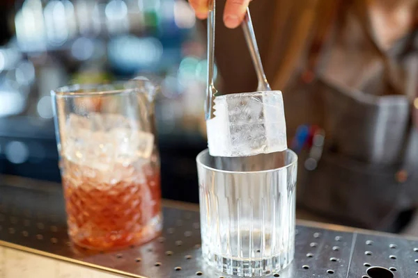 Barista aggiungendo cubetto di ghiaccio in vetro al bar — Foto Stock