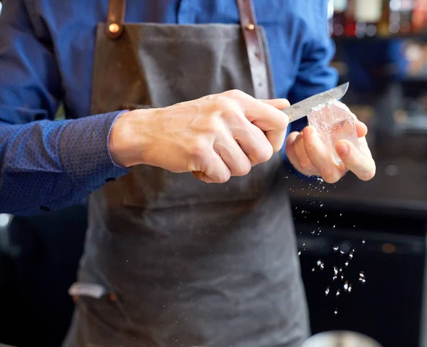 Camarero moliendo cubo de hielo con cuchillo en la barra — Foto de Stock