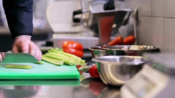 Руки чоловіка шеф кухаря готують нарізати селеру на кухні — стокове відео
