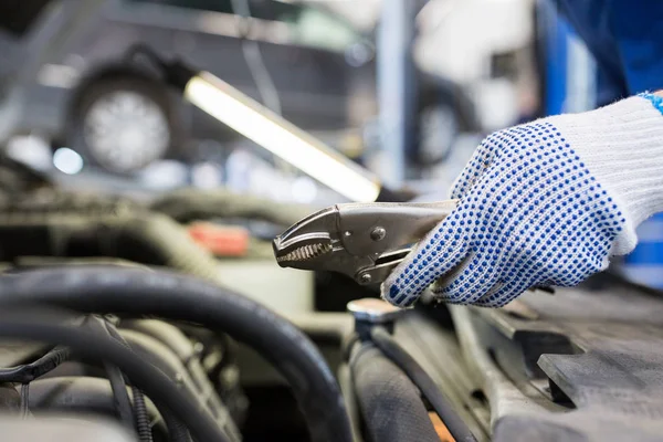 Meccanico con pinze riparazione auto in officina — Foto Stock