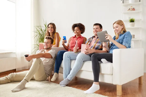 Amigos com gadgets e cerveja assistindo tv em casa — Fotografia de Stock