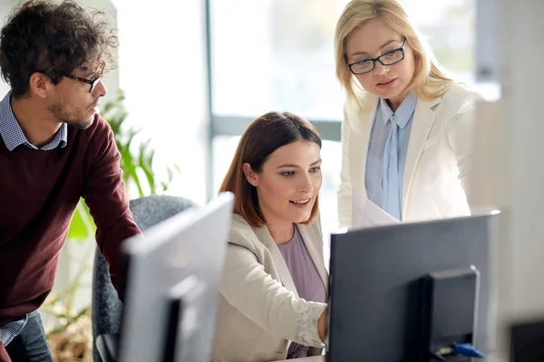 Equipe de negócios feliz com computador no escritório — Fotografia de Stock