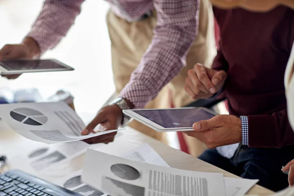 Hommes d'affaires avec tablette PC et graphiques au bureau — Photo