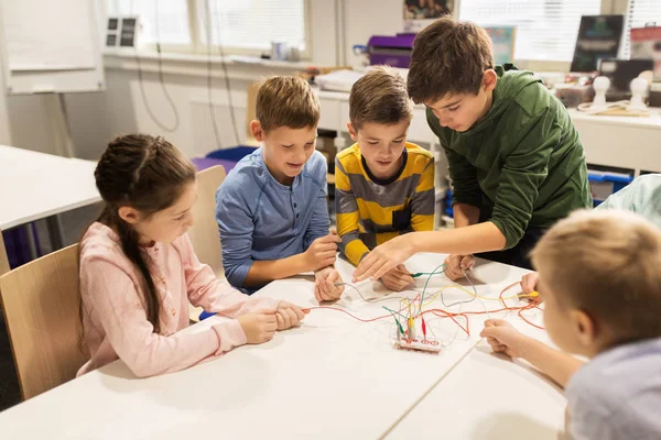 Gelukkige jonge geitjes met uitvinding kit op robotica school — Stockfoto