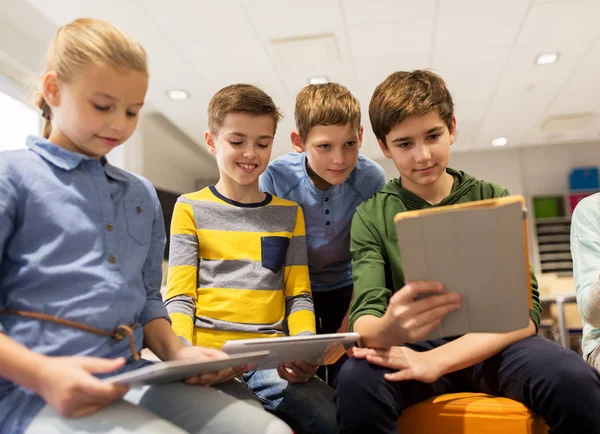 Group of happy children with tablet pc at school — Stock Photo, Image