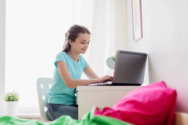 Kız evde dizüstü bilgisayarda yazarak — Stok fotoğraf
