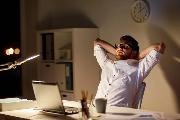 Man met laptop rekken bij nacht kantoor — Stockfoto