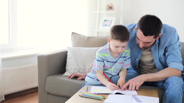 Vater und kleiner Sohn mit Buntstiftzeichnung zu Hause — Stockvideo