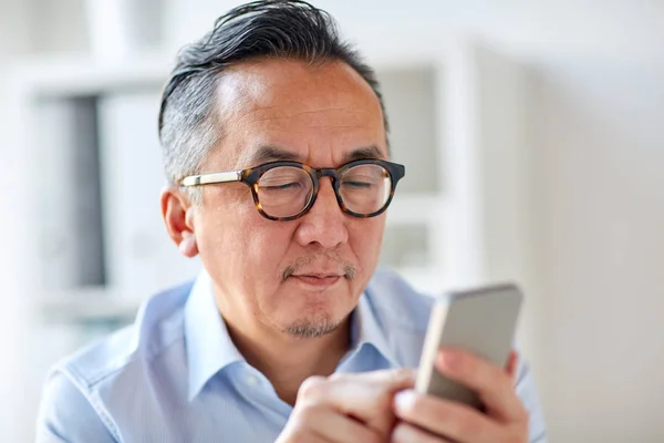 Affärsman textning på smartphone på kontor — Stockfoto