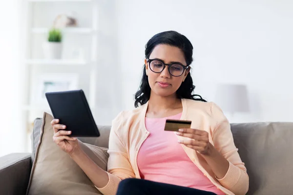 Szczęśliwa kobieta z tabletem i kartą kredytową w domu — Zdjęcie stockowe