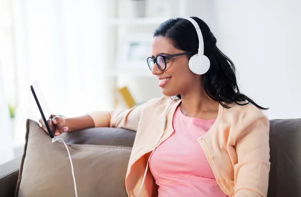 Mujer feliz con tablet pc y auriculares en casa — Foto de Stock