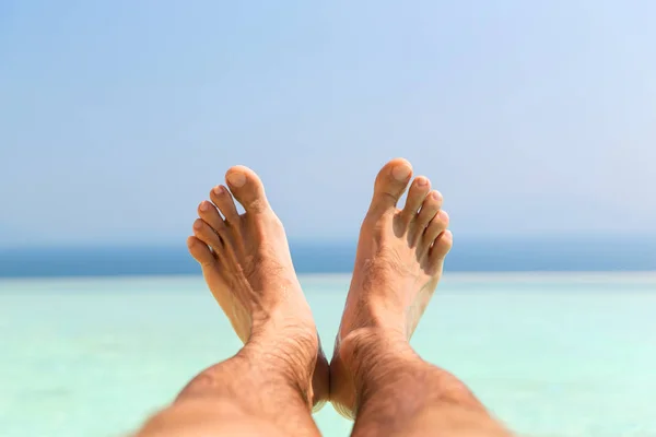 Manliga fötter på stranden — Stockfoto