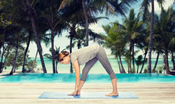 Donna rendendo yoga posa tratto intenso sul tappeto — Foto Stock