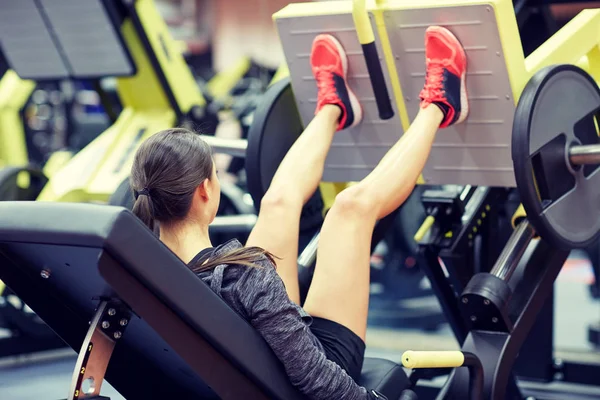 Kadın spor salonunda bacak presi makinesinde kaslarını esnetiyor. — Stok fotoğraf