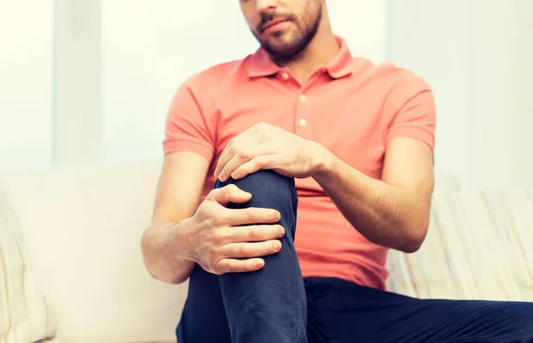 Close up of man suffering from pain in leg at home — Stock Photo, Image