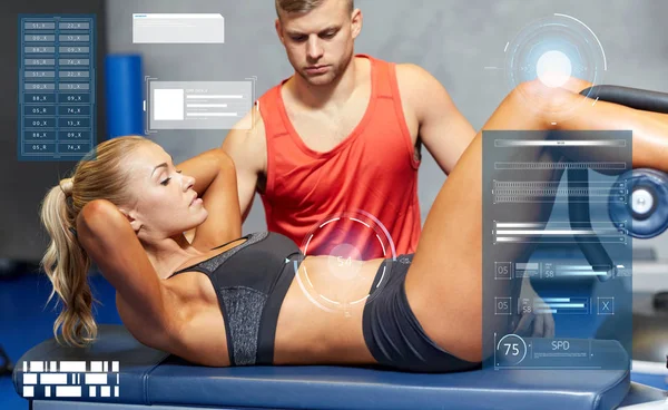 Mulher com personal trainer fazendo sit ups no ginásio — Fotografia de Stock