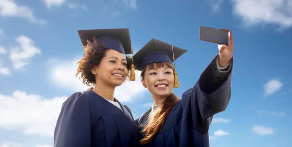 Estudiantes tomando selfie por teléfono inteligente sobre el cielo azul — Foto de Stock