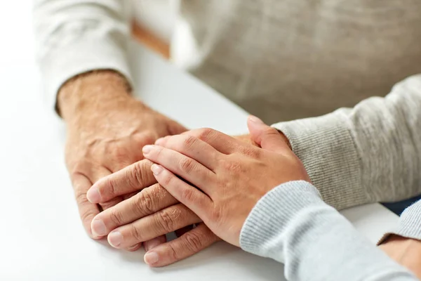 Primer plano de hombre viejo y mujer joven tomados de la mano —  Fotos de Stock