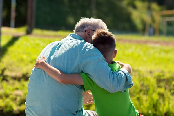 Abuelo y nieto abrazándose al aire libre —  Fotos de Stock